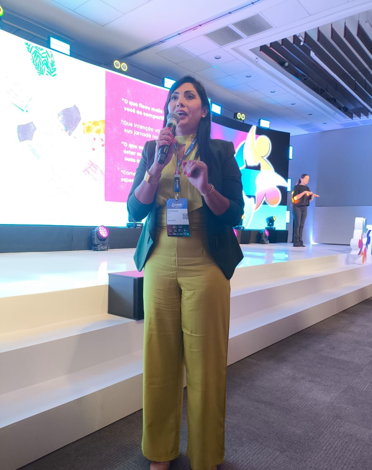 Cristiane Garcias com microfone no palco do ESARH 2025